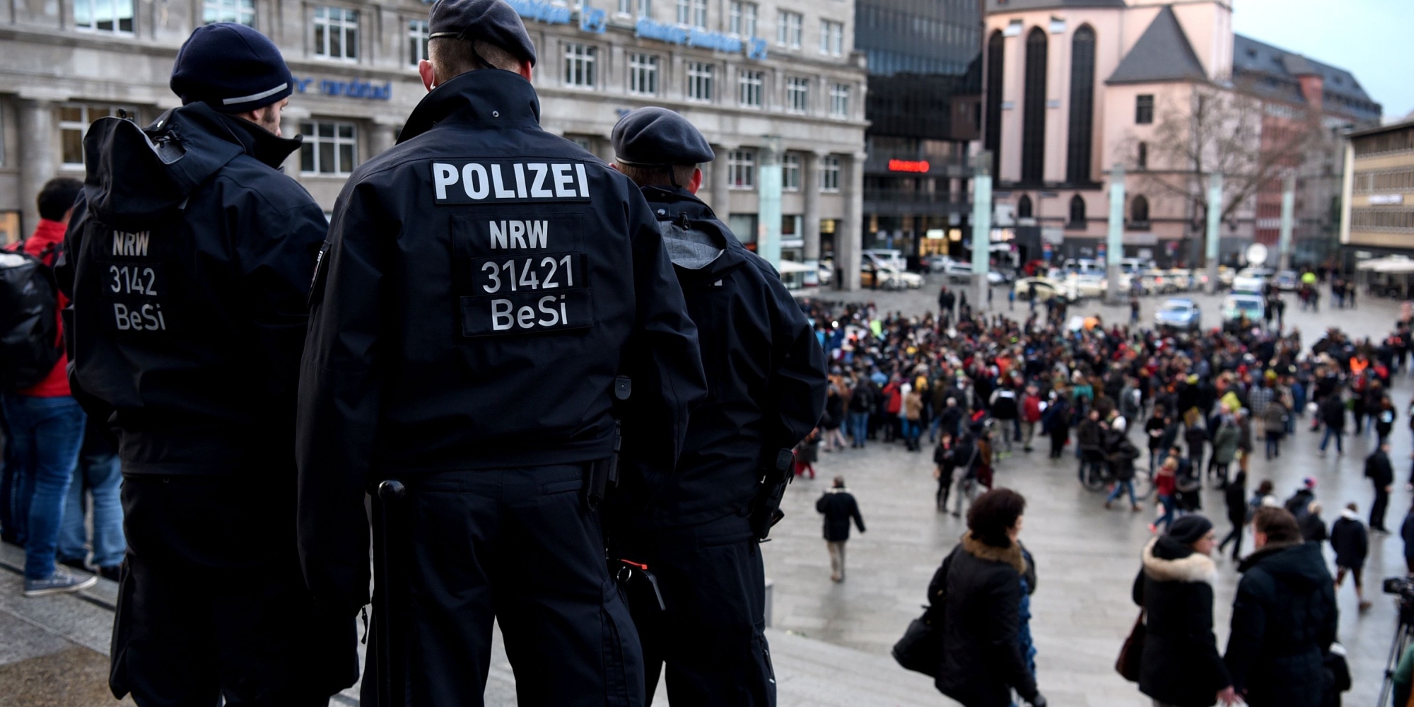Policemen look on as refugees from Syria demonstrate against violence near the Cologne main train station in Cologne, western Germany on January 16, 2016, where hundreds of women were groped and robbed in a throng of mostly Arab and North African men during New Year's festivities. German authorities said that nearly all the suspects in a rash of New Year's Eve violence against women in Cologne were "of foreign origin", as foreigners came under attack amid surging tensions. / AFP / PATRIK STOLLARZ (Photo credit should read PATRIK STOLLARZ/AFP/Getty Images)