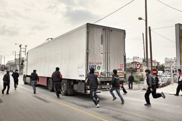 2012. Patras. Greece. A group of adolescents trying to illegally board trucks going to Italy. A group of Afghan boys aged 14 to 18 years, on a traffic island. Every day, these kids try to illegally board trucks going towards Italy. One of the most common ways of illegally leaving Greece which is attempted is the illegal boarding of goods trucks which will subsequently be loaded onto cargo ships for Italy. Over the years, many young people have lost their lives attempting this, while others have been stopped by the police. Only a very small percentage manages to succeed in this desperate attempt. Patras is one of the main escape points from Greece, due to the numerous cargo ships that dock in the port and are bound for Italy. It is therefore one of the points where it is possible to attempt to escape from Greece.
